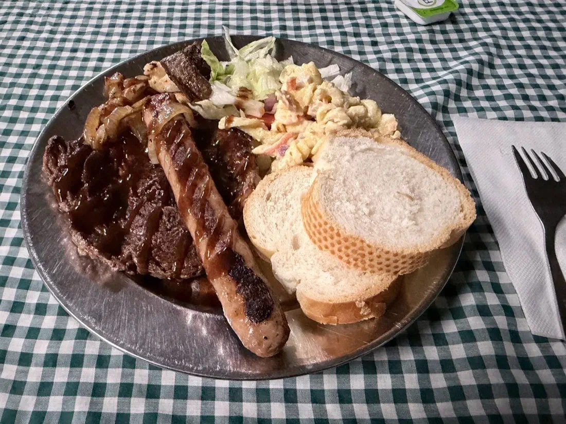 BBQのお皿:ステーキ、ソーセージ、パン、サラダ
