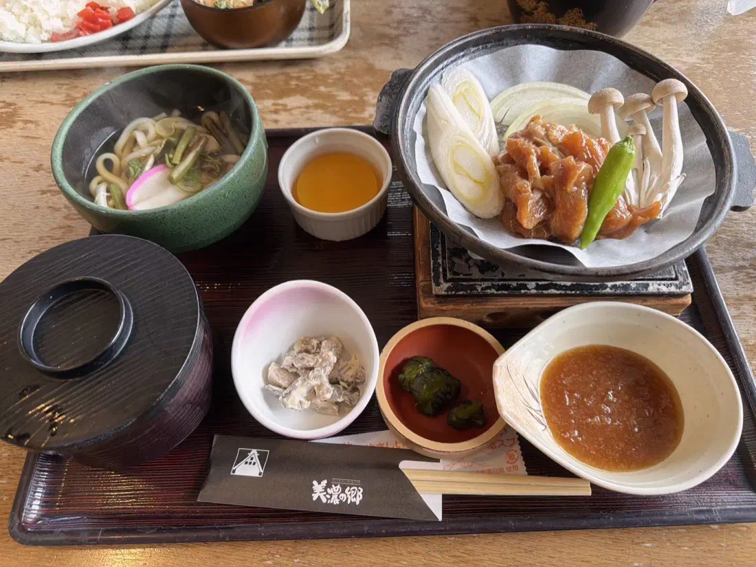 鶏ちゃんの定食。鉄鍋の上の鶏肉と野菜、うどん、小鉢