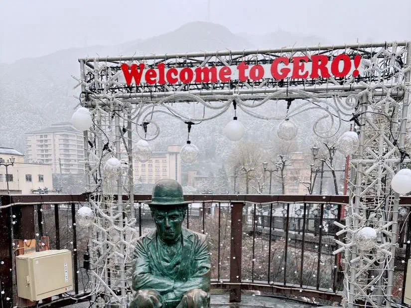 雪の日の「Welcome to GERO!」の看板と、チャップリンの像
